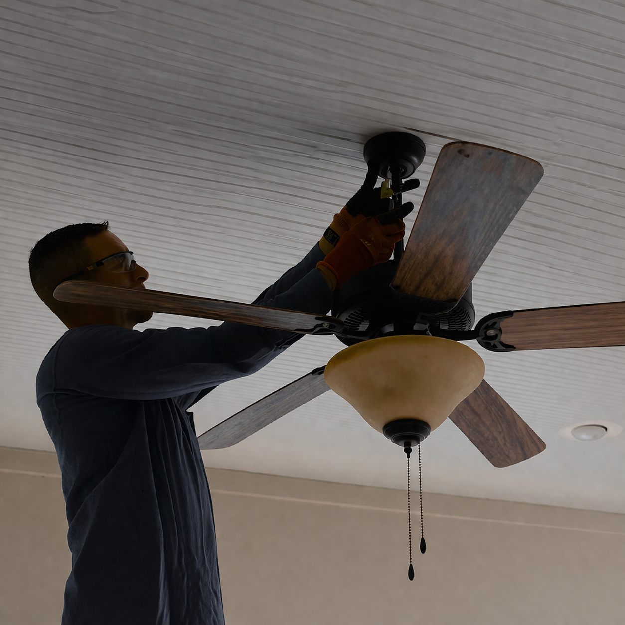 Electrician installing a ceiling fan